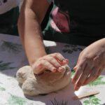 Kinder füttern Ziegen auf grünem Bauernhof im Salzburger Land, Familienurlaub mit Tieren