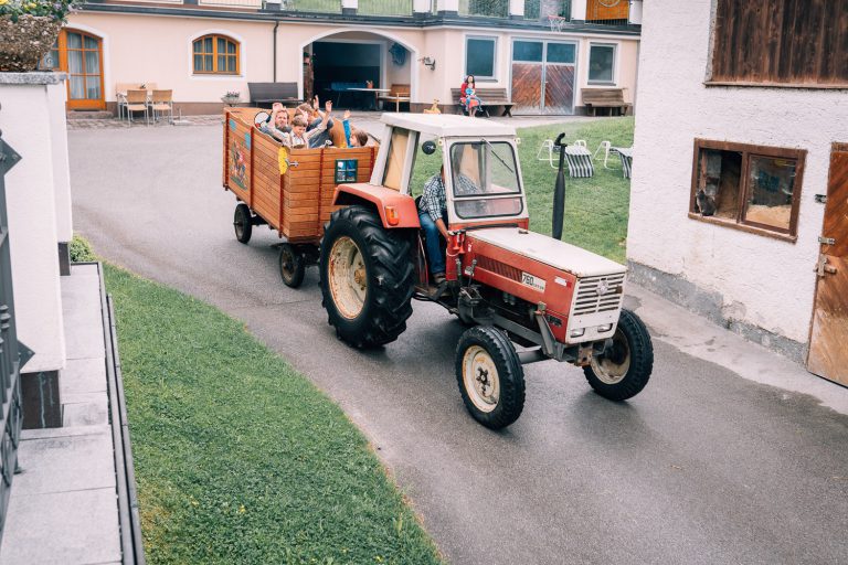 Tractor with a Trailer Full of Happy Children on a Farm Path